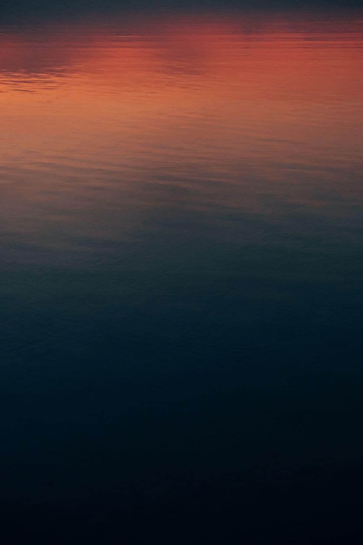 Sunset reflections on a still lake surface